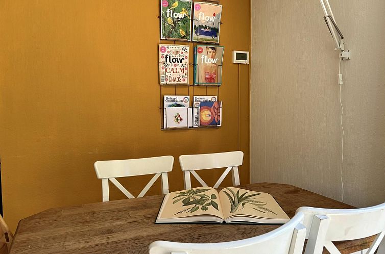 Dining room in Tiny Lodge Basic in Harderwijk, Veluwe. Cozy room with wooden table and magazines.
