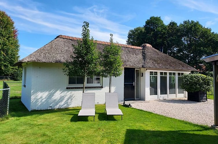 Vacation cottage in Heerde with thatched roof and green garden on the Veluwe, Gelderland.