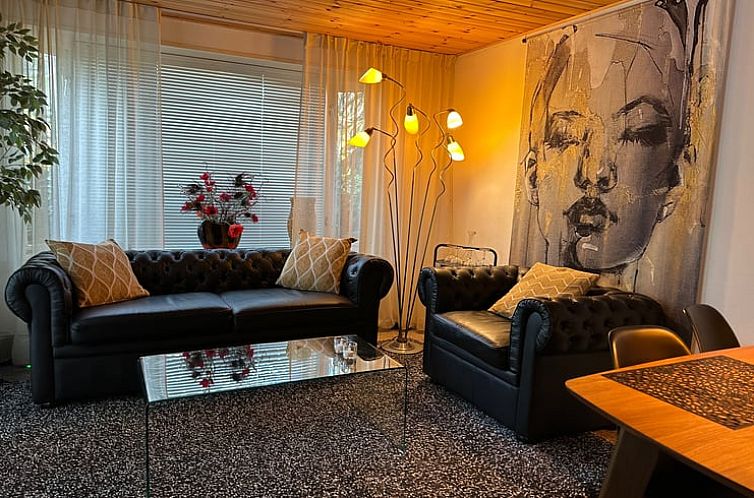 Gezellige woonkamer Vakantiehuis in Hattemerbroek met comfortabele banken en kunst, Veluwe, Gelderland.