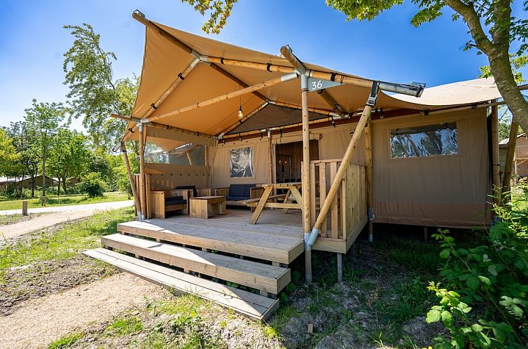 Geniet van de rust in Safaritent 6, een luxe glamping lodge in Vierhuizen, Noordwest Groningen met een ruime veranda en natuurlijke omgeving.