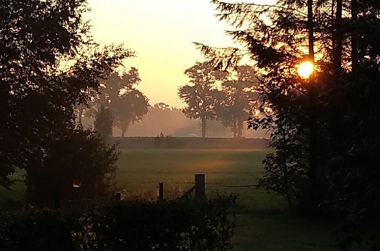 Ontwaak met een serene zonsopgang bij Huisje in Marum, vakantiehuis in de groene natuur van Zuidwest Groningen.