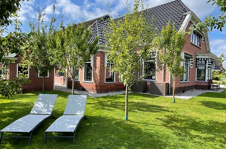 Vakantiehuis in Midwolde met groene tuin en ligstoelen, Zuidwest Groningen.
