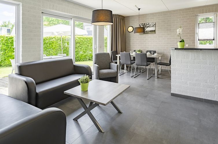 Moderne woonkamer in vakantiehuis Jansberg 6, Plasmolen, Noord Limburg met comfortabele zithoek en grote ramen voor veel natuurlijk licht.