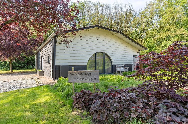 L224 vakantiehuis in Merselo, Noord Limburg met een charmante tuin en bankje voor ontspanning.