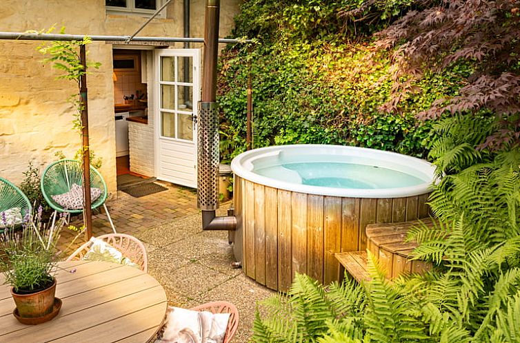 Geniet van de jacuzzi op het terras van Vakantiehuis in Valkenburg, Zuid Limburg, omringd door weelderige natuur.
