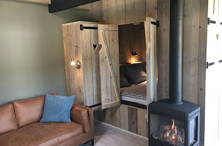 Cozy living room with fireplace in Holiday Home in Oisterwijk, North Brabant.