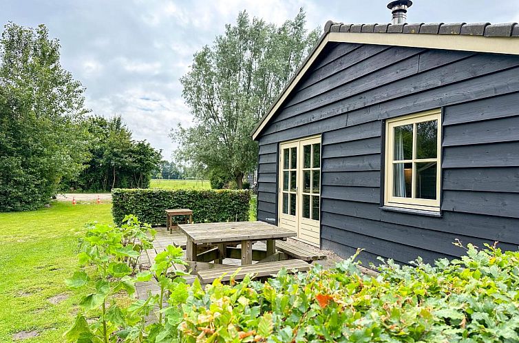 Fire cottage in Lage Zwaluwe, North Brabant with wooden terrace and green surroundings.