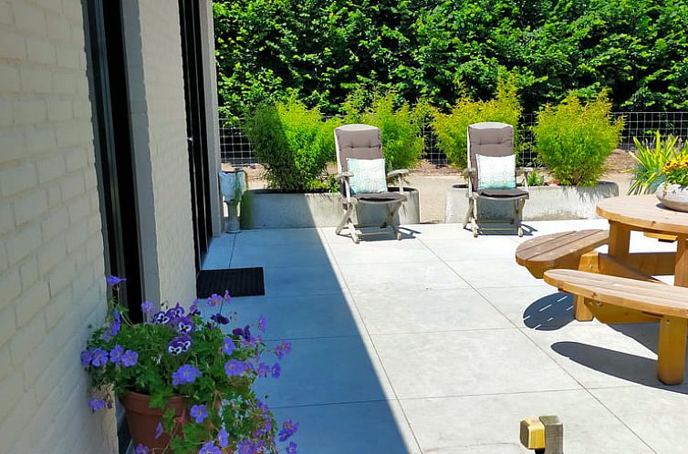 Terrace of Holiday home in Ulvenhout AC with comfortable chairs and green frame in West Brabant.