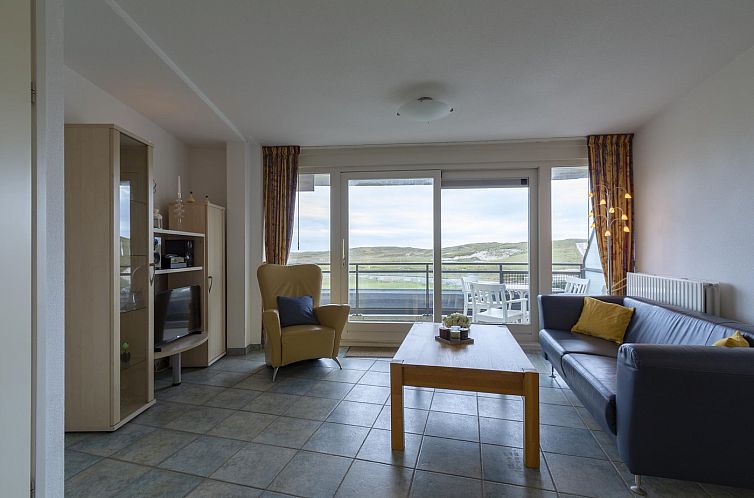 Gezellige woonkamer in vakantiehuis Wijde Blick 206 Callantsoog aan de Noordzeekust, met uitzicht op duinen.