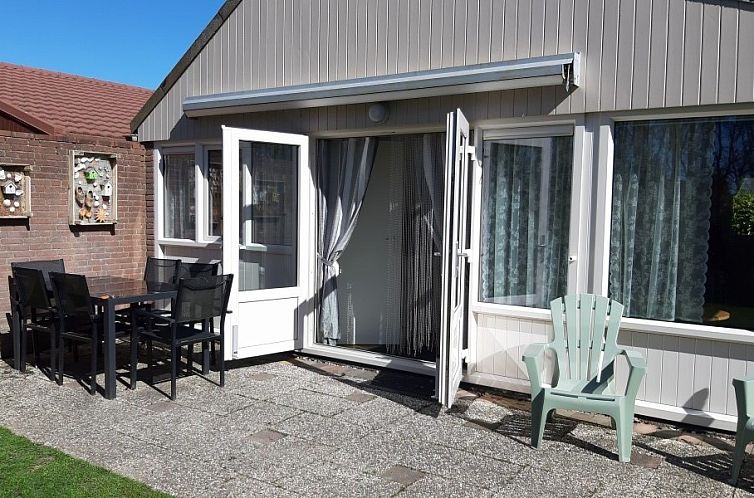Veranda of vacation home Rekere 111 in Schoorldam, North Sea coast, North Holland with seating and open doors.