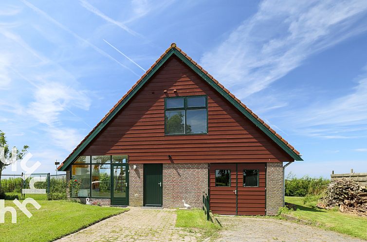 Vakantiehuis NH064 in Burgerbrug, Noordzeekust, Noord-Holland met charmante houten gevel en groene omgeving.
