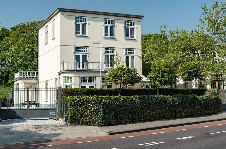 Villa de Berk, ein stilvolles Ferienhaus in Zandvoort an der Nordseekueste, Nordholland, umgeben von gruener Natur.