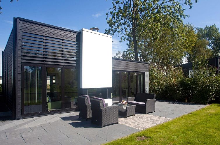 Geniet van de moderne Cube Elite 6 vakantiewoning met terras in Halfweg, Noordzeekust, Noord-Holland, omgeven door natuur.