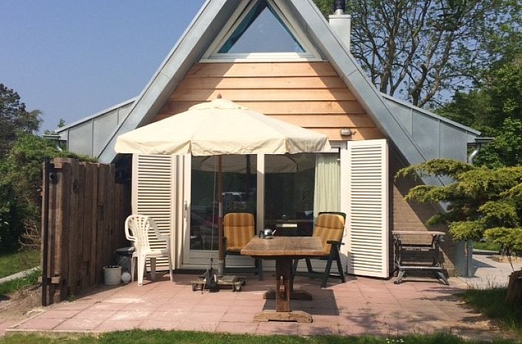 Gezellig terras van strandhuis Sandepark 31 in Callantsoog, Noordzeekust, Noord-Holland, met parasol en tuinmeubilair.