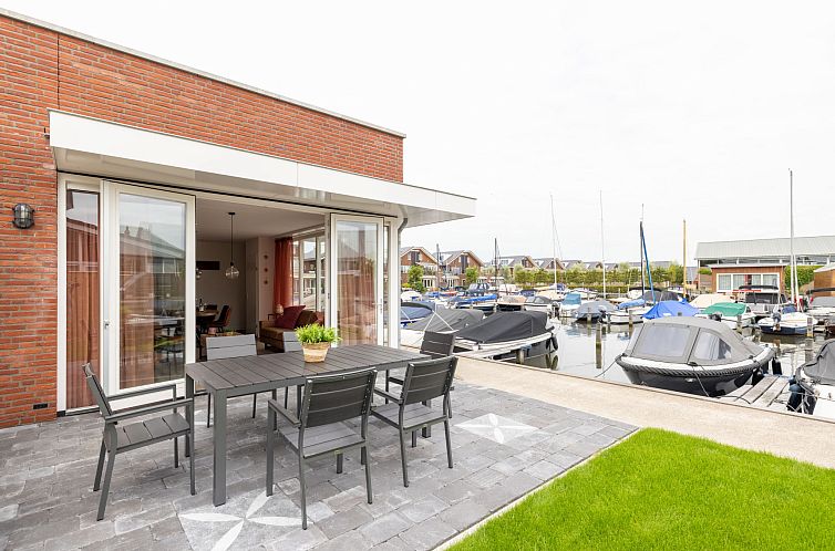 Terras bij Vakantiehuis De Meerparel in Uitgeest met uitzicht op de jachthaven in Noord-Holland.