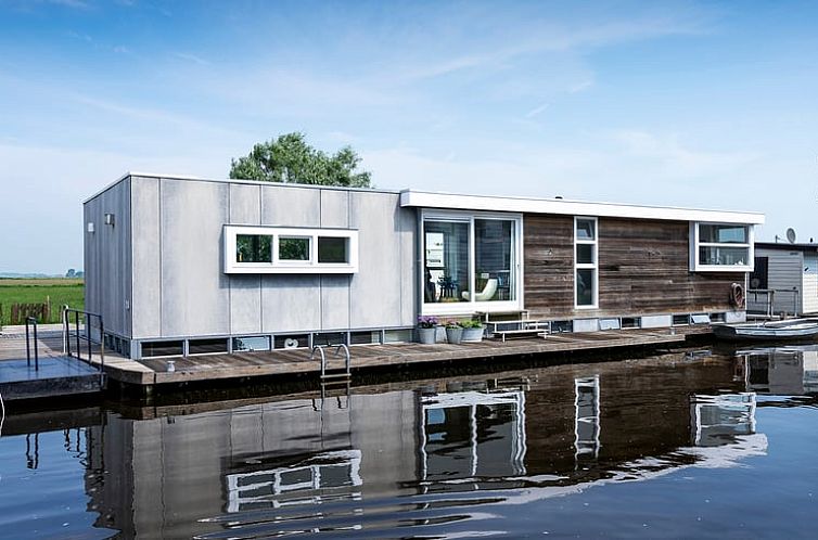 Moderne vakantiehuis Huisje in Broek in Waterland, Amsterdam, met houten en glazen gevel aan het water in Noord-Holland.