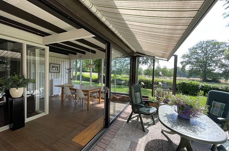 Veranda des Ferienhauses in Ootmarsum mit Blick auf die gruene Natur in Twente, Overijssel.