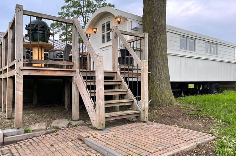 Verhoogd terras bij Vakantiehuisje in Markelo, Twente, Overijssel met houten trap en uitzicht op groene natuur.