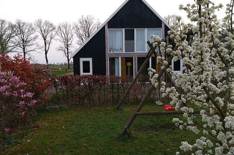 De Bosuil vakantiehuis in Punthorst, Overijssel, met bloeiende tuin en schommel in landelijke omgeving.