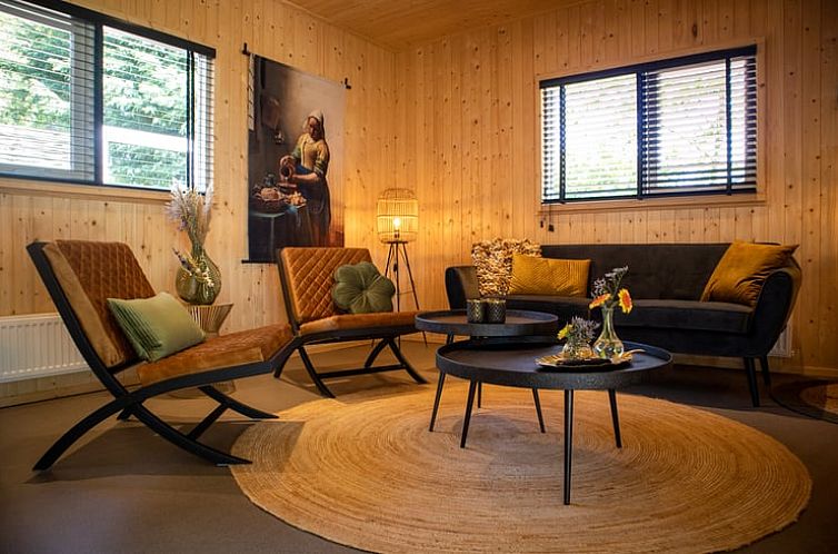Gezellige woonkamer van Vakantiehuis in Bruchterveld, Vechtstreek, Overijssel met houten interieur en comfortabele zitplaatsen.