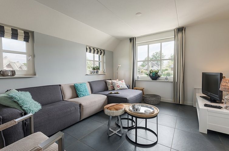 Gezellige woonkamer in vakantiehuis Breeuw 4, Wanneperveen, Overijssel, met comfortabele banken en veel natuurlijk licht.