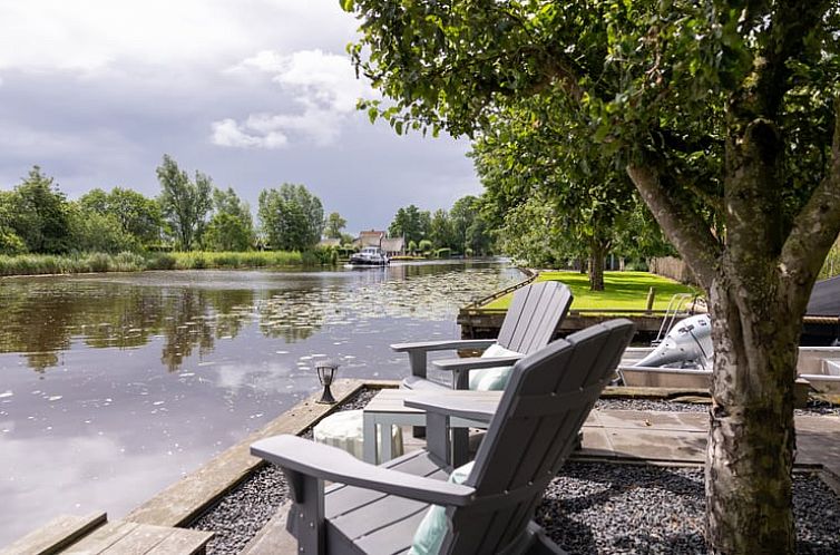 Gezellige woonkamer in Vakantiehuisje in Wetering, Overijssel met groene muur en comfortabele zitplaatsen.