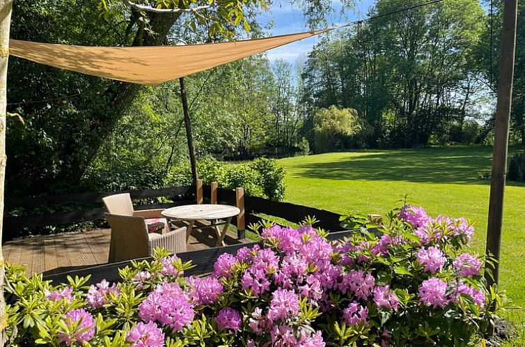 Gezellig terras bij Huisje in Tienhoven, vakantiehuis in Tienhoven, Utrecht, met uitzicht op groene tuin en bloemen.