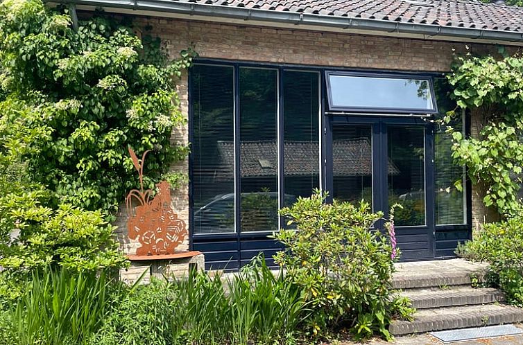 Vacation home in Doorn with green facade on the Utrecht Hill Ridge.