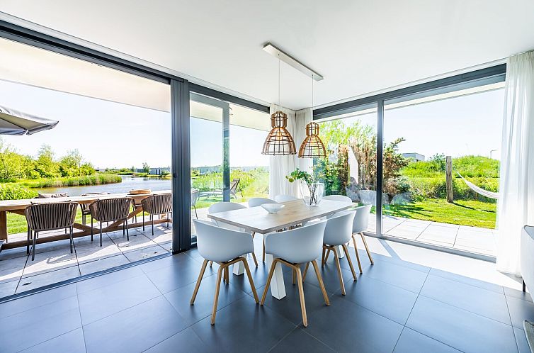 Dining room overlooking garden in Duinvallei 32, vacation home in Kamperland, Zeeland.