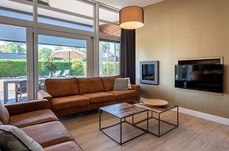 Cozy living room in Vinkenlaan 14 | De Banjaard, vacation home in Kamperland, Zeeland with comfortable seating area.