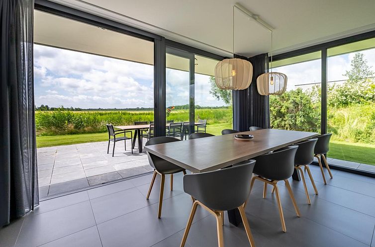 Eetruimte in Waterlijn 16 | De Groote Duynen, vakantiehuis in Kamperland, Noord-Beveland, met uitzicht op groene velden.