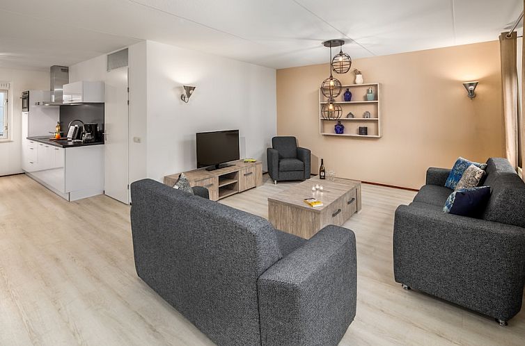 Stijlvolle woonkamer van Villa R6C, een vakantiehuis in Kamperland, Noord-Beveland, Zeeland met moderne inrichting en comfortabele zithoek.