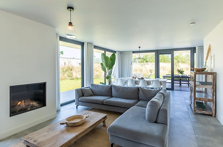 Ruime woonkamer in Waterlijn 31 | De Groote Duynen, Kamperland, vakantiehuis met moderne inrichting en open haard.