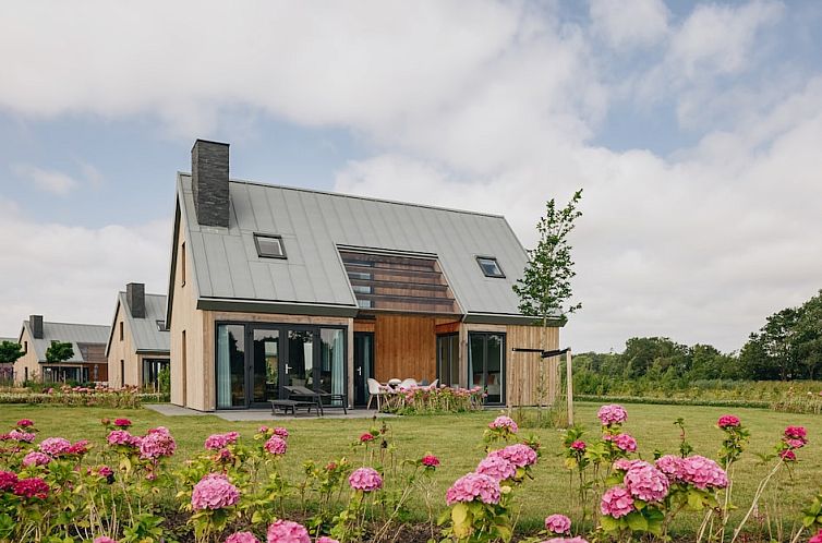 Villa Keats 6, a modern vacation home in Kamperland, North Beveland, Zeeland, surrounded by beautiful gardens and a spacious veranda.