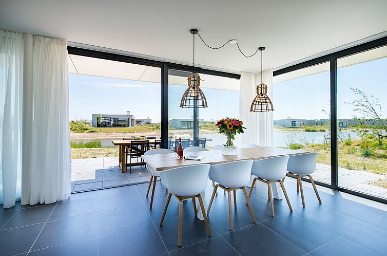 Modern dining room in Zandbank 18 | De Groote Duynen, Kamperland, overlooking nature and water.