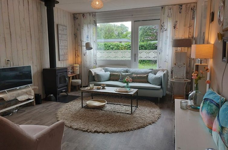 Gezellige woonkamer van vakantiehuis De Garnaal in Renesse, Zeeland met sfeervolle inrichting en uitzicht op de tuin.