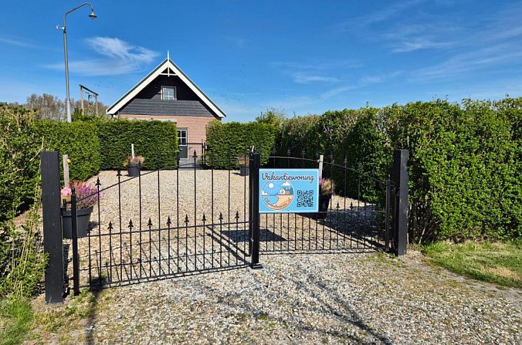 Toegangspoort van Ellemeet aan zee, een vakantiehuis in Ellemeet, Schouwen-Duiveland, omgeven door groene heggen.