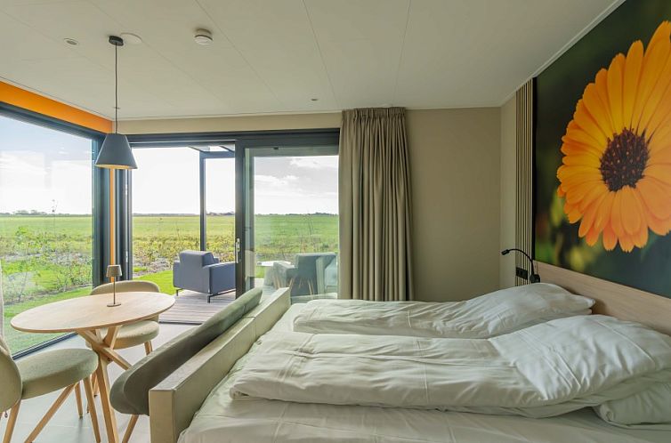 Lichte slaapkamer met uitzicht op groene velden bij Buitenplaats Hotel, bed and breakfast in Ellemeet, Schouwen-Duiveland, Zeeland.