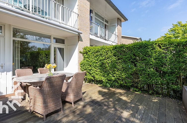 Veranda of vacation home ZE744 in Oostkapelle, Walcheren, Zeeland with wooden table and wicker chairs.
