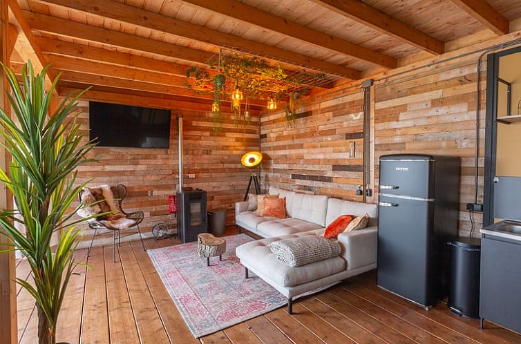 Gezellige woonkamer in Vakantiehuis in Middelburg, Walcheren, Zeeland met houten interieur en comfortabele zithoek.