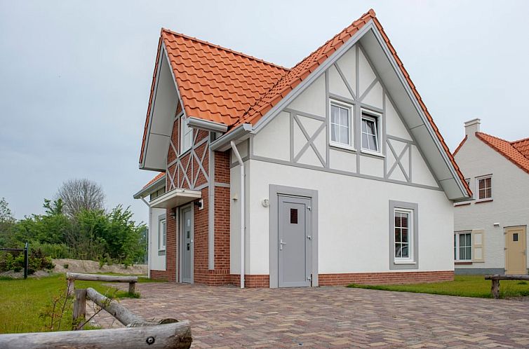 Charmant vakantiehuis Villa 8M in Cadzand-bad, Zeeuws-Vlaanderen met rode dakpannen en groene omgeving, ideaal voor een ontspannend verblijf.