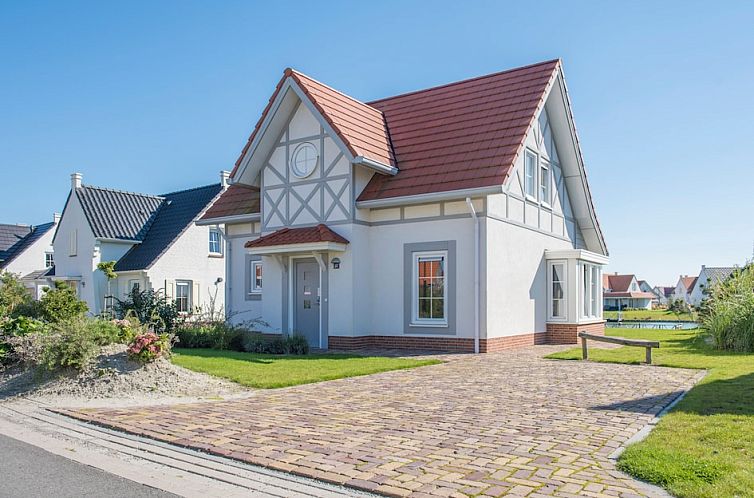 Cozy living room in Villa 6A, a vacation home in Cadzand-bad, Zeeuws-Vlaanderen, with comfortable sofas and views of nature.