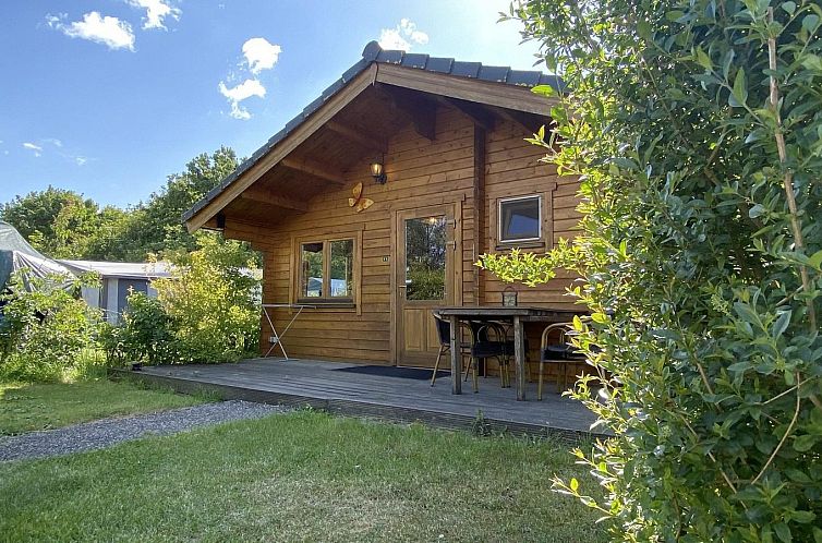 VZ851 Holiday chalet in Ossenisse, Zeeuws-Vlaanderen, wooden chalet with veranda surrounded by greenery.