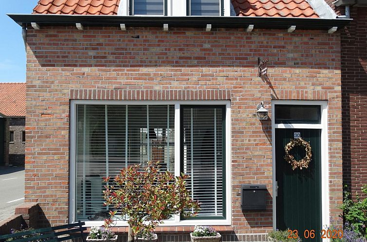 Vooraanzicht van VZ885 Vakantiehuis in Biervliet, Zeeuws-Vlaanderen, met charmante bakstenen gevel.