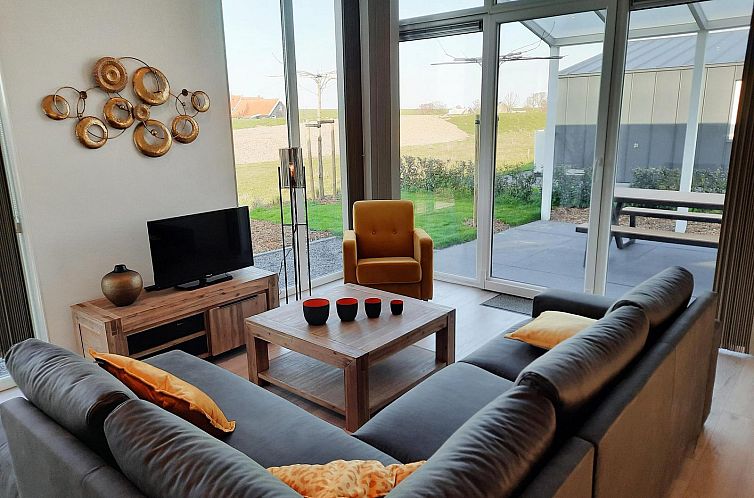 Cozy living room in Holiday home Waterresort Oosterschelde house no. 83 in Wemeldinge, South Beveland, overlooking the garden.