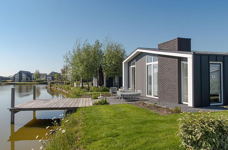 Vakantiehuis Waterresort Oosterschelde huisnr. 28 in Wemeldinge met uitzicht op het water en groene omgeving.