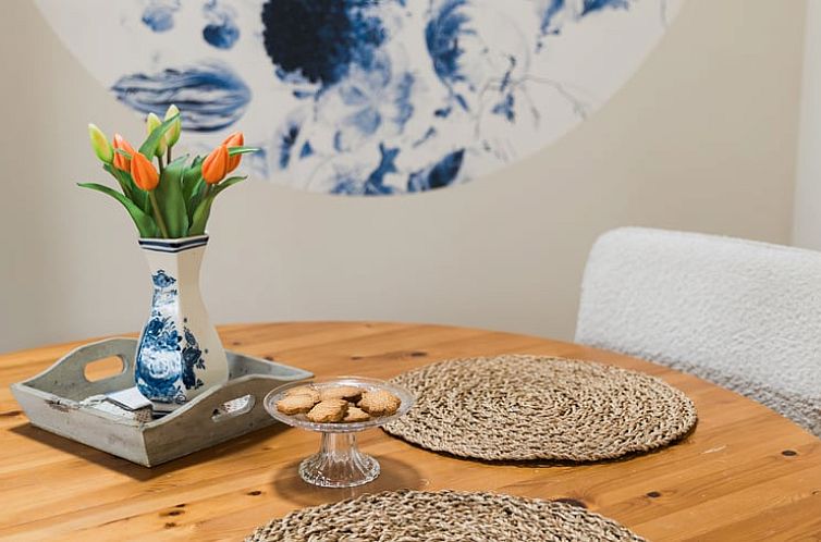 Gezellige eetruimte in Vakantiehuis in Lewedorp, Zuid-Beveland met rustieke houten tafel en decoratieve elementen.