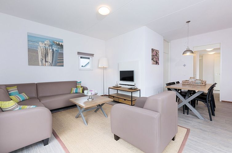 Cozy living room of Bungalow 6C in Ouddorp, Goeree-Overflakkee, South Holland, with comfortable sitting area and modern dining area.