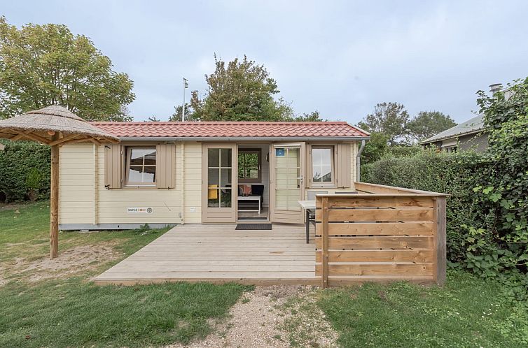 Camping chalet the Sea Eagle in Ouddorp with wooden veranda and green surroundings, ideal for a relaxing vacation in Goeree-Overflakkee.