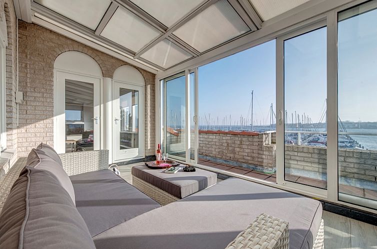 Geniet van het panoramische uitzicht op de jachthaven vanuit de zonnige veranda van Comfort 6 appartement in Ouddorp, Zuid-Holland.